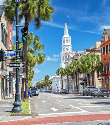 A street view of Charleston, South Carolina featuring historic buildings and a church tower.