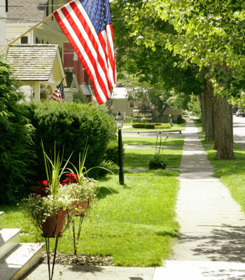 A tree-lined street in Fuquay-Varina, North Carolina with American flags adorning homes.